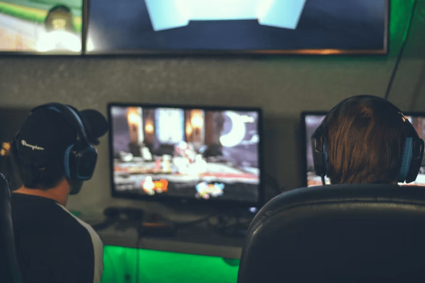 A viewer watches an esports tournament from a multi-monitor gaming setup.